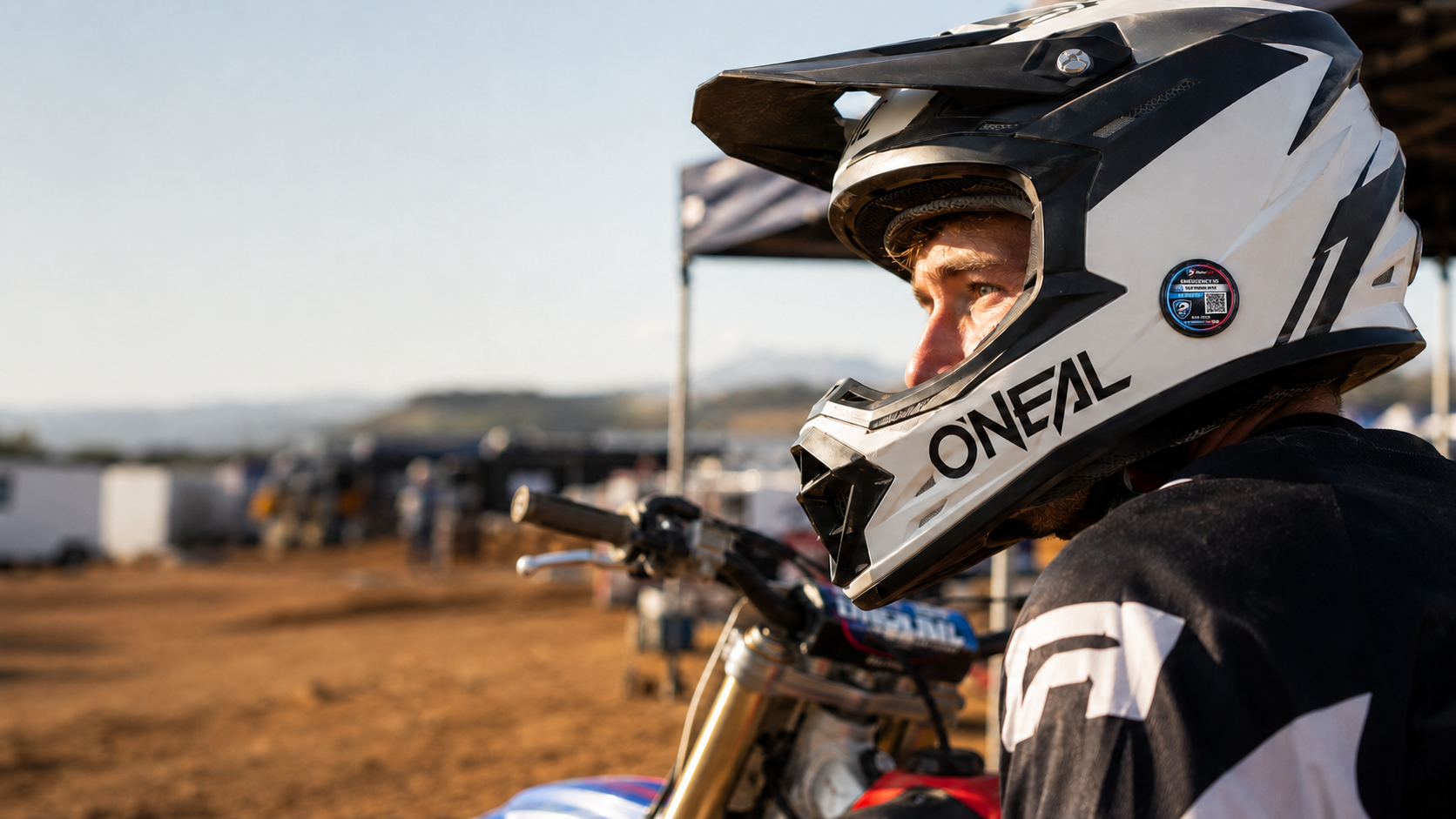 Motocross rider wearing a helmet fitted with a RiderSOS emergency ID tag